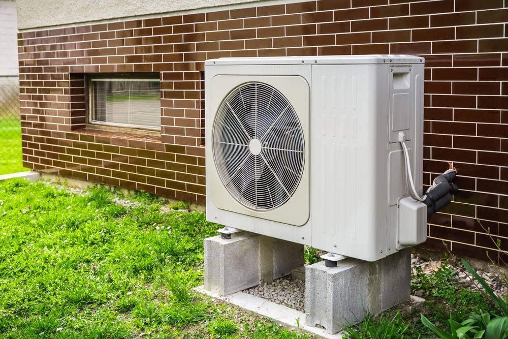 A heat pump next to a wall 