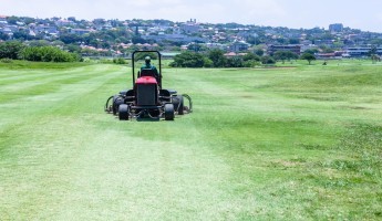 fairway mower on a golf course in the summer