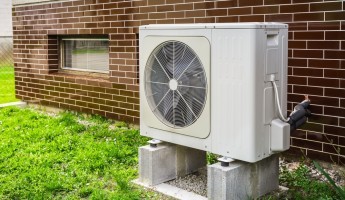 A heat pump next to a wall 