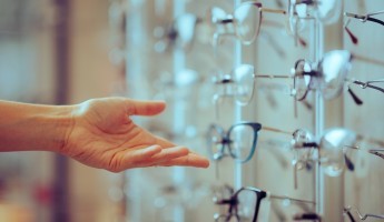 A person about to pick up glasses in an opticians