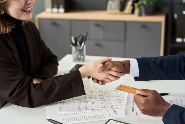 Woman Getting Credit Card From Manager