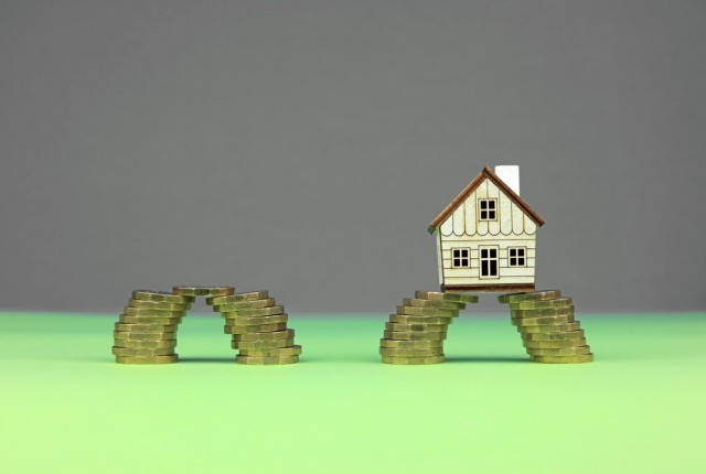 A model house with a stack of coins