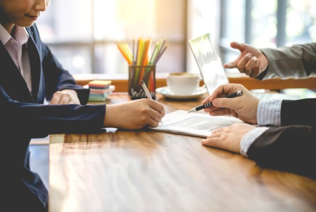 Business person signing a document