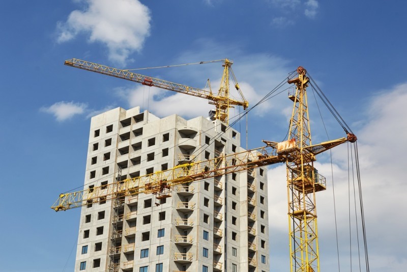 two cranes in between a building