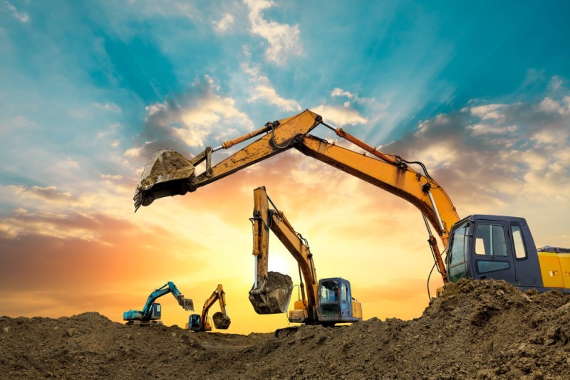 Multiple construction assets preparing a site