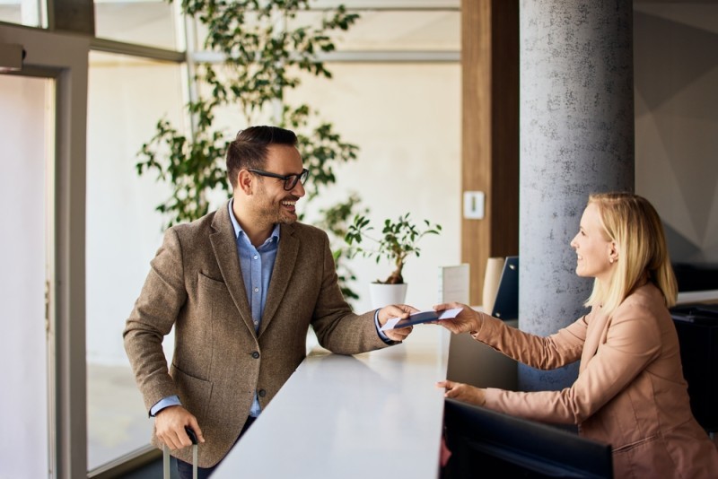A receptionist handing over a card to a man